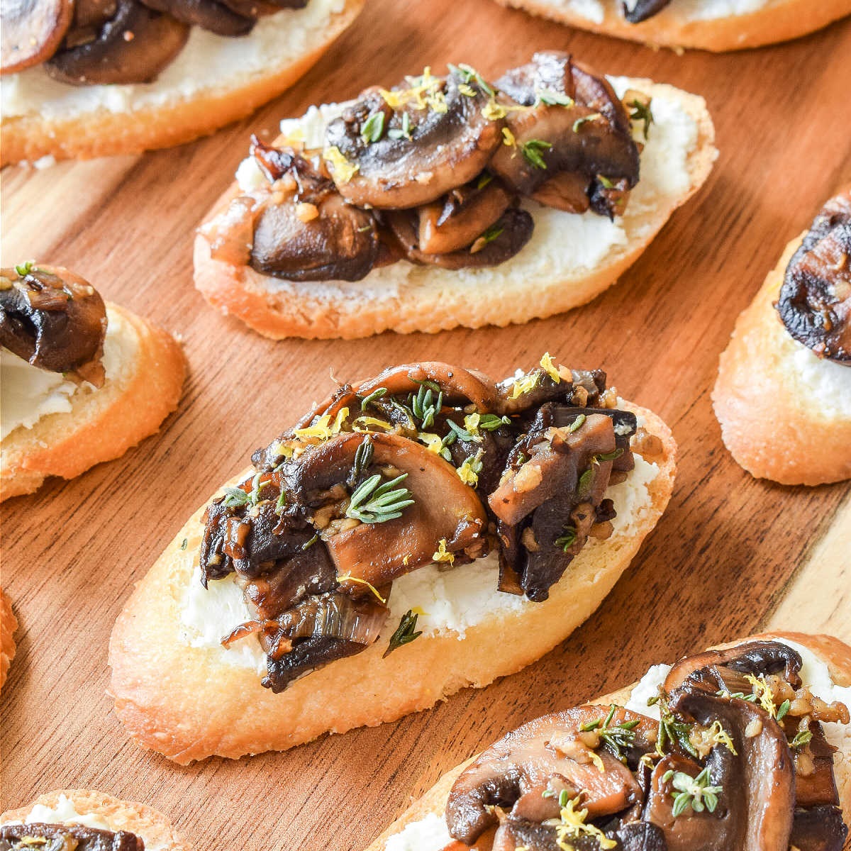 Bake sliced baguette with olive oil and salt, then chop mushrooms while sauteing shallots and garlic. Cook mushrooms until thickened, season, and top crostini